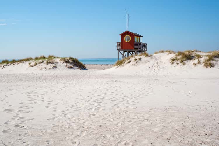 beach with white sand and pier into the sea